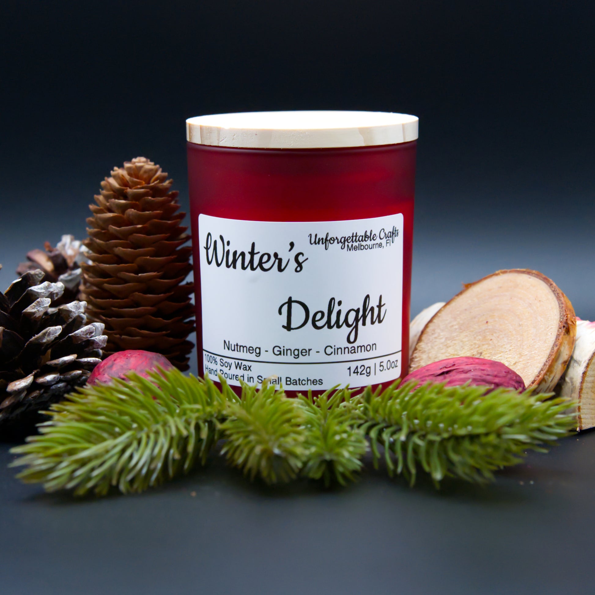 Candle labeled 'Winter's Delight' with decorative elements on a dark background