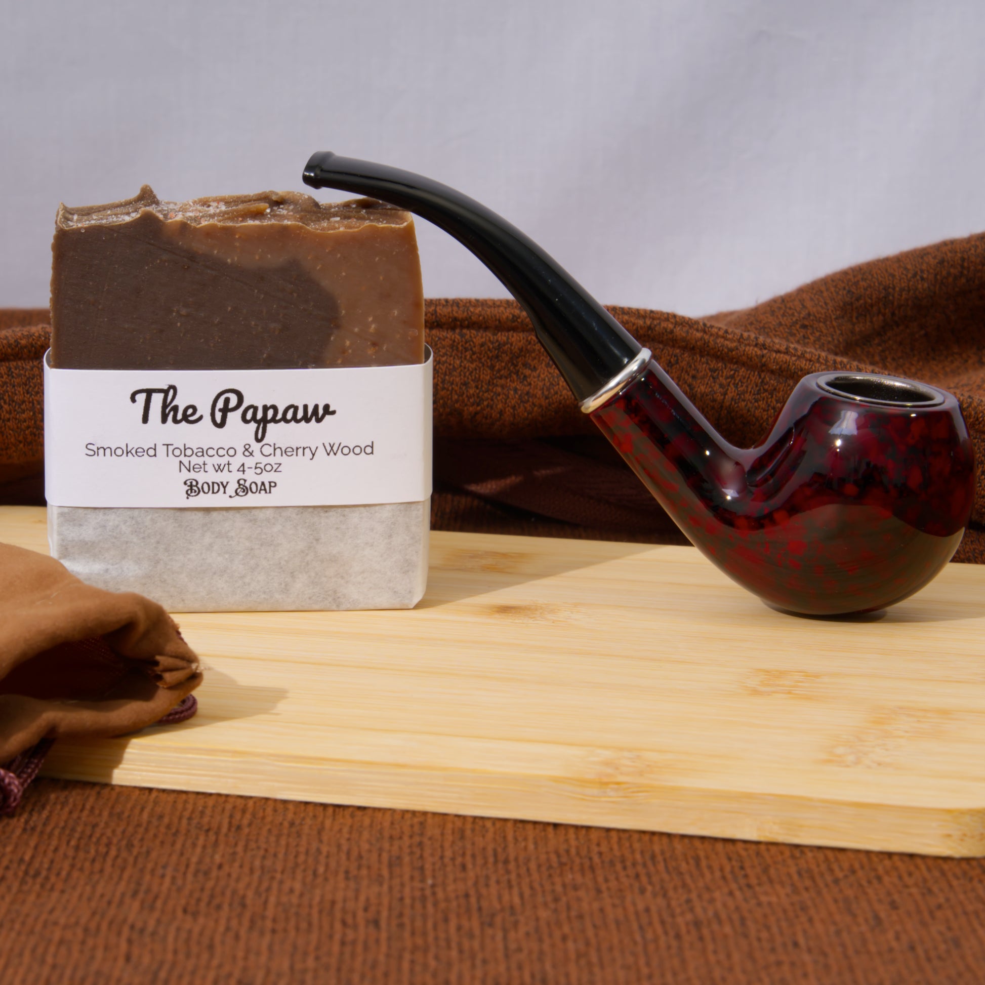 Bar of soap labeled 'The Papaw' with a smoking pipe on a wooden surface.