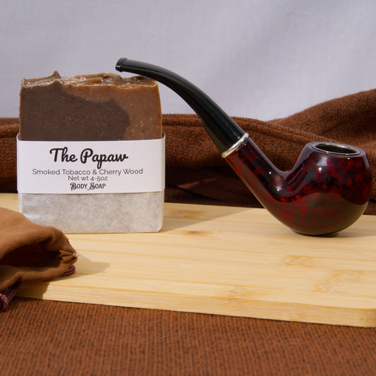 Bar of soap labeled 'The Papaw' with a smoking pipe on a wooden surface.
